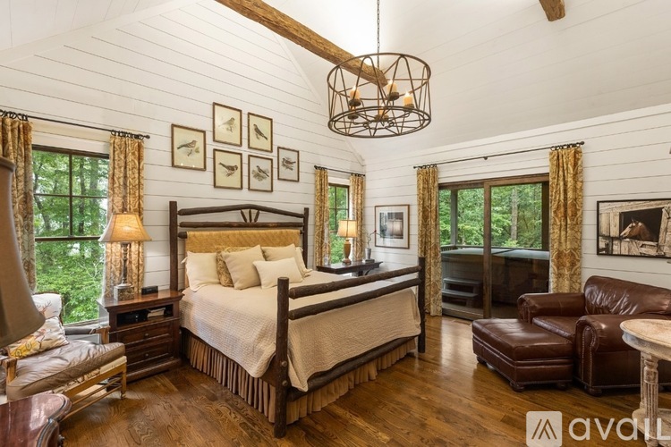 A bedroom with a large bed and a wooden floor.