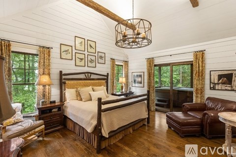 A bedroom with a large bed and a wooden floor.