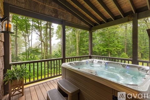 A hot tub on a wooden deck with a view of the forest.