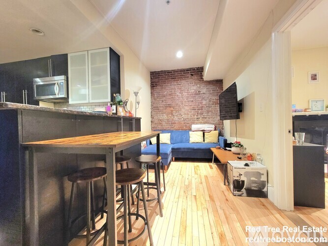 A kitchen with a brick wall and a bar area.