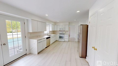 A spacious kitchen with white cabinets and a large island.