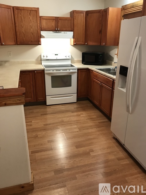 A kitchen with wooden cabinets and white appliances.