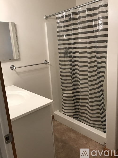 A bathroom with a white sink and a shower curtain with a striped pattern.