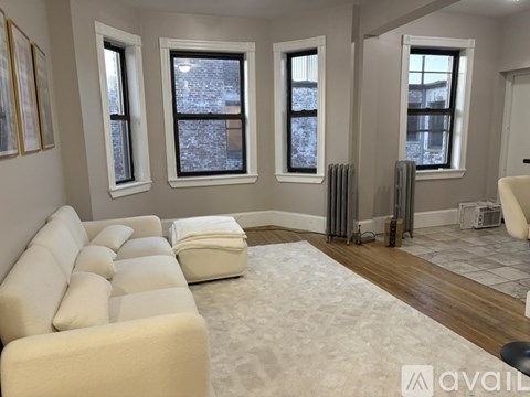 A living room with a white couch and a rug.