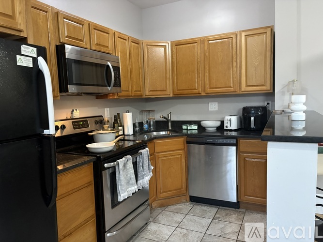 A kitchen with wooden cabinets and black appliances.