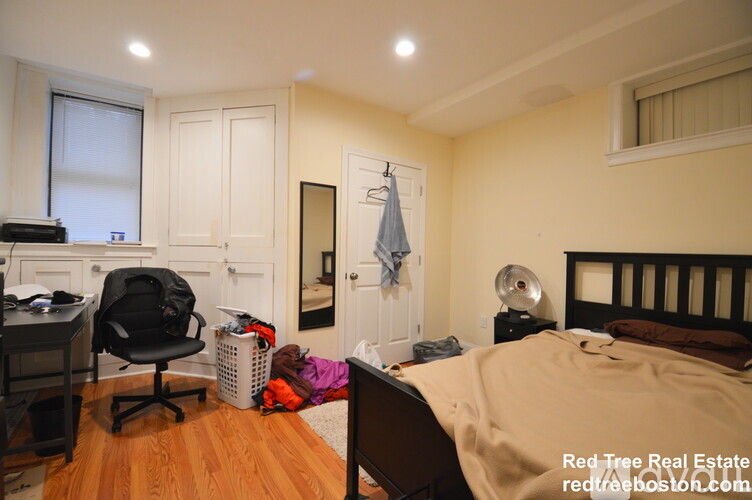 A bedroom with a bed, desk, and chair.