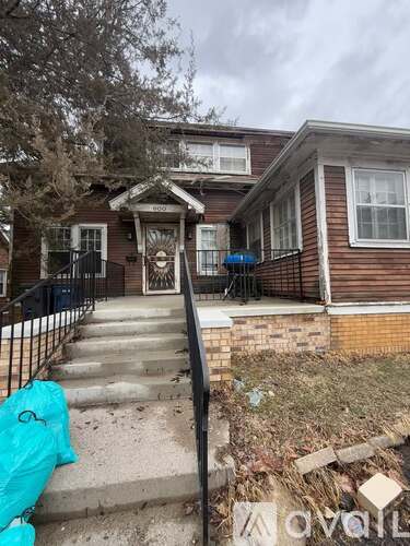 A house with a front yard and a black fence.