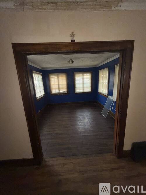 A room with a wooden floor and a large mirror on the wall.
