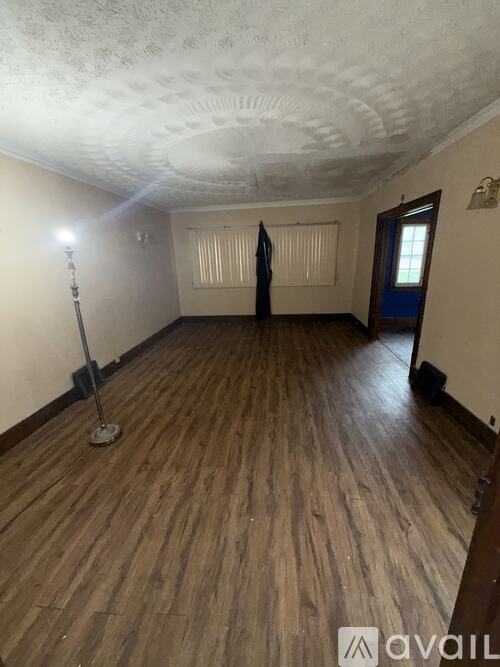 A room with wooden flooring and a ceiling with a pattern.