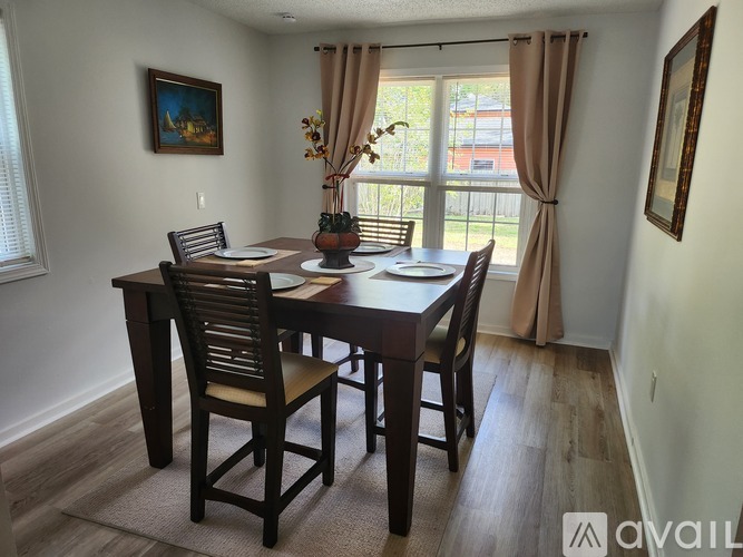 A dining room with a wooden table and chairs.
