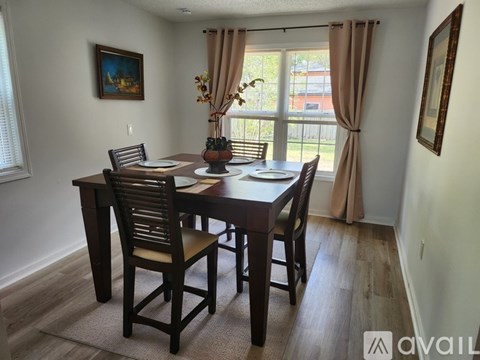 A dining room with a wooden table and chairs.