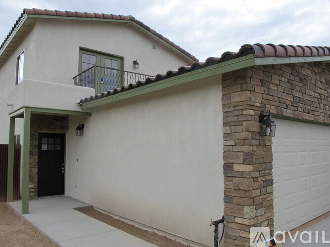 A house with a balcony and a garage door.