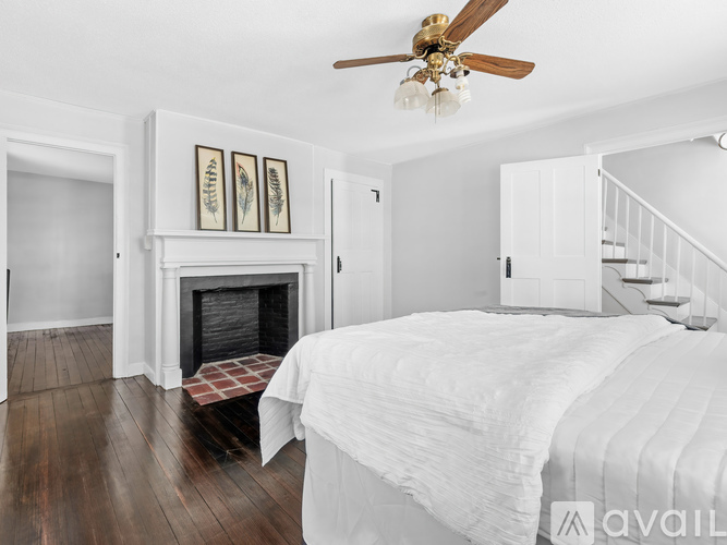 A bedroom with a large bed and a fireplace.
