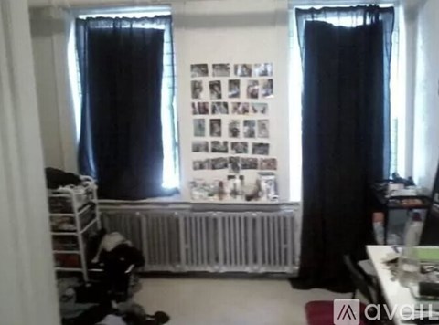 A room with a radiator and pictures on the wall.