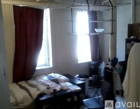A bedroom with a bed, desk, and chair.