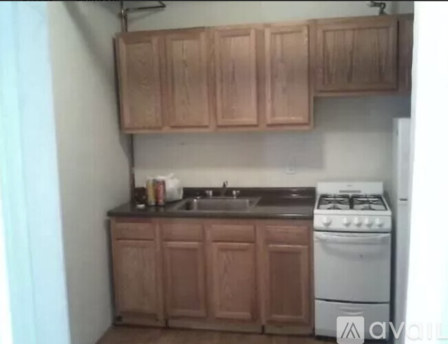 A kitchen with wooden cabinets and a white stove.