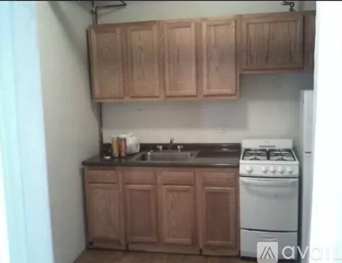 A kitchen with wooden cabinets and a white stove.