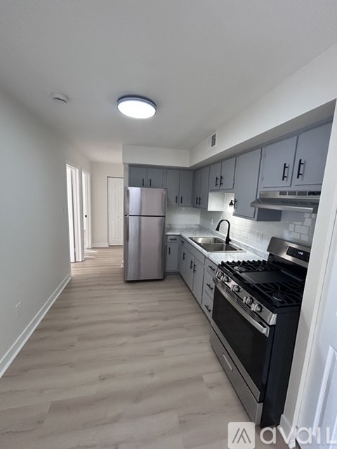 A kitchen with a stove, refrigerator, and cabinets.