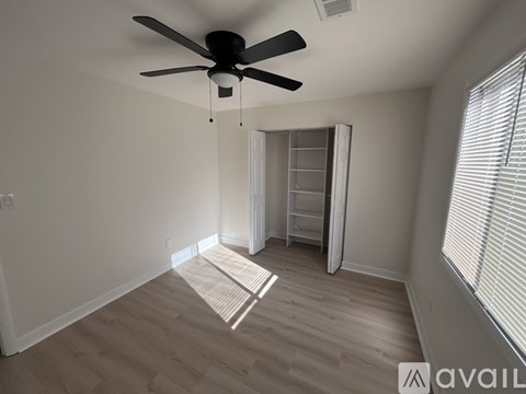 A room with a ceiling fan and a ladder in it.