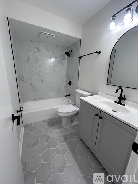 A bathroom with a marble tile shower and a white toilet.
