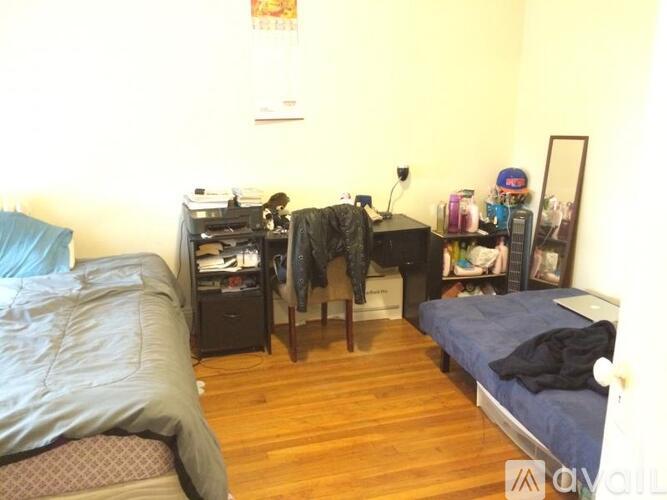 A bedroom with a bed, desk, and chair.
