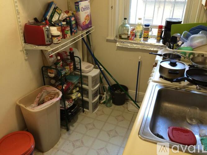 A kitchen with a sink, toaster, and other items on the counter.