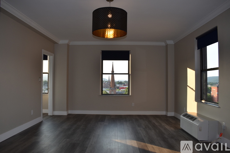 A room with a large window and a picture on the wall.