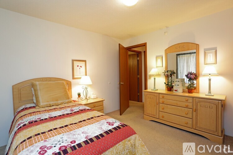 A bedroom with a bed, dresser, and mirror.