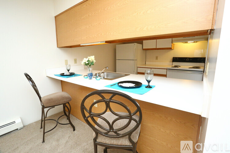 A kitchen with a table and chairs.