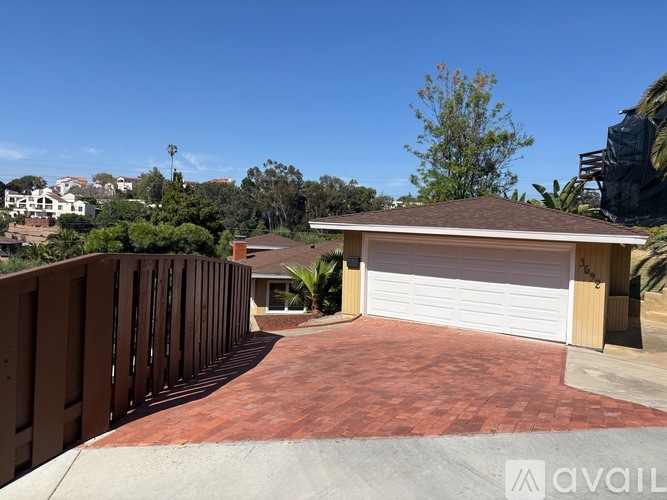 A house with a garage and a driveway leading to it.