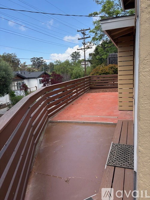 A wooden deck with a red surface and a metal grate.