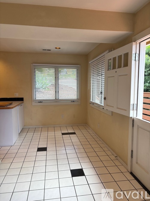 A room with a tile floor and a window with blinds.