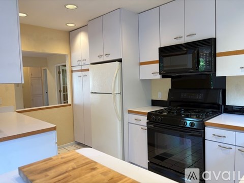 A kitchen with white cabinets and a black stove top oven.