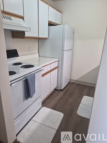 A kitchen with white appliances and cabinets.