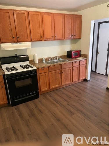 A kitchen with wooden cabinets and a black stove top.
