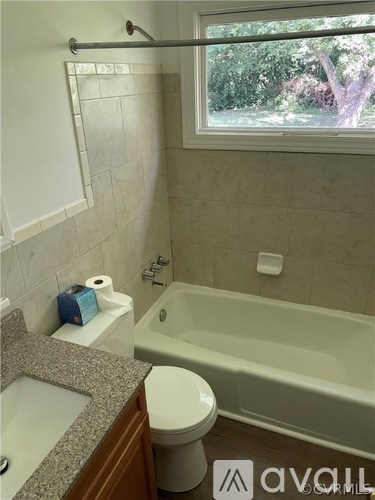 A bathroom with a tub, toilet, and sink.
