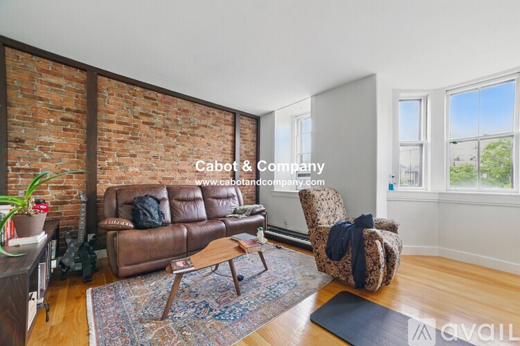 A living room with a brown leather couch and a wooden coffee table.