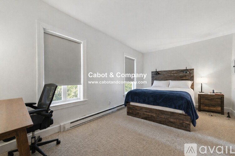 A bedroom with a bed, desk, and chair.