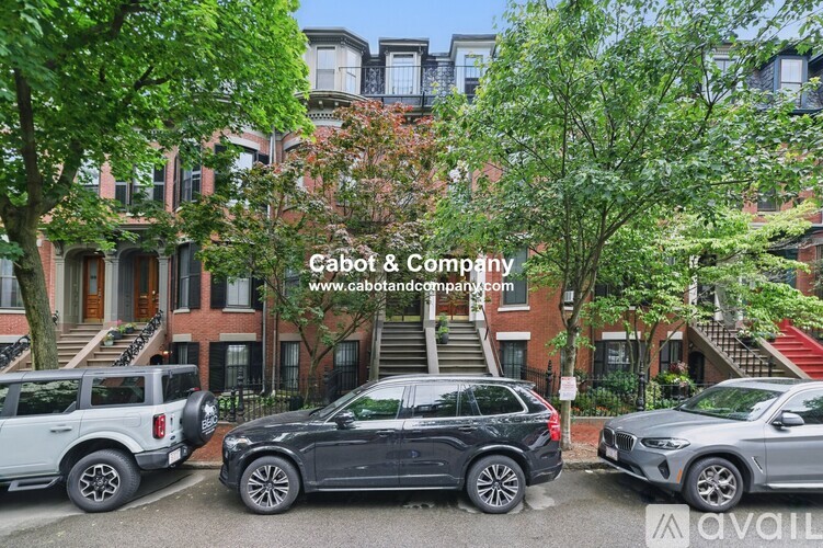 A black SUV is parked in front of a building with the text "Cabot & Company" on it.