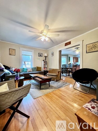A living room with a black chair and a wooden floor.