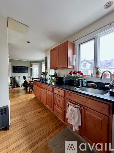 A kitchen with wooden cabinets and a black countertop.