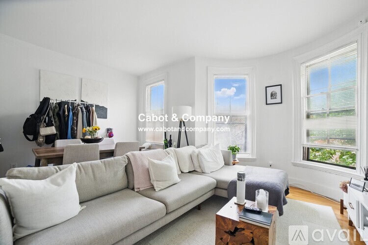 A living room with a white couch and a wooden coffee table.