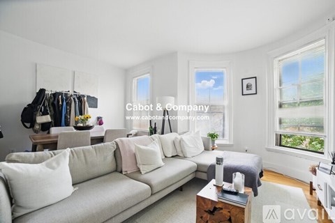 A living room with a white couch and a wooden coffee table.