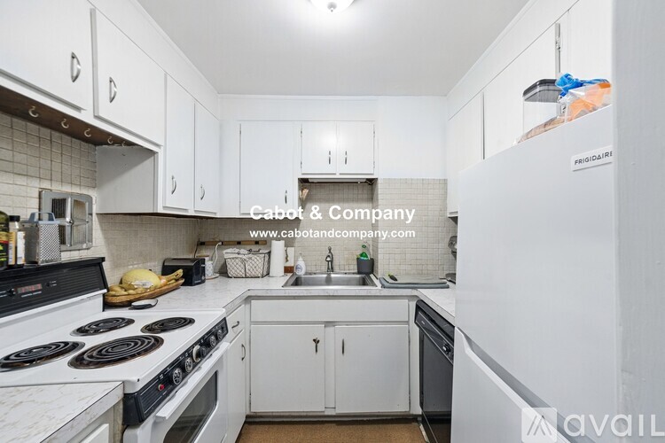 A kitchen with white cabinets and a black stove top oven.
