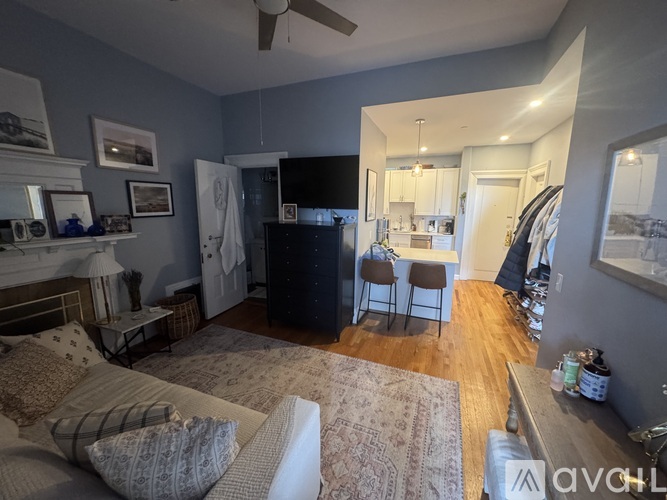 A living room with a couch, a chair, a television, and a fireplace.