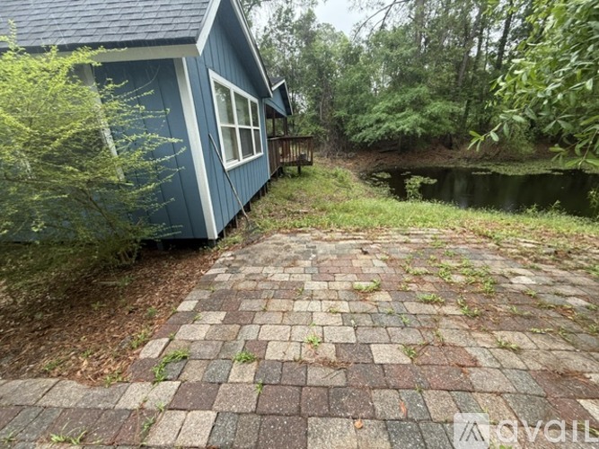A blue house with a brick walkway in front.