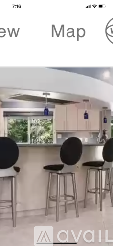 A modern kitchen with a bar area featuring three stools.