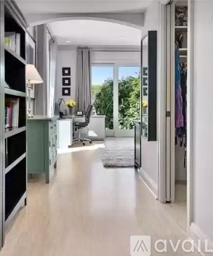 A spacious hallway with a sliding glass door leading to a balcony.