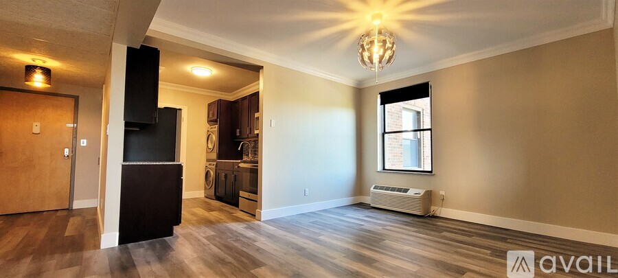 A spacious living room with wood flooring and a large window.