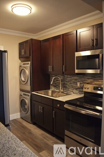 A kitchen with dark wood cabinets and stainless steel appliances.